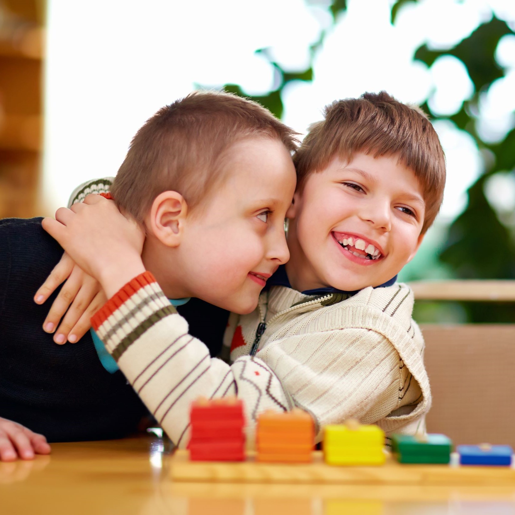 Two young disabled boys hugging and playing. Clinsura's services help Medicaid recipients in Minnesota and offers home-based care collaboration and mental health services.